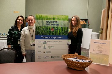 Beheshteh, Hunter, and Rebecca stand by a National FHB Forum sign