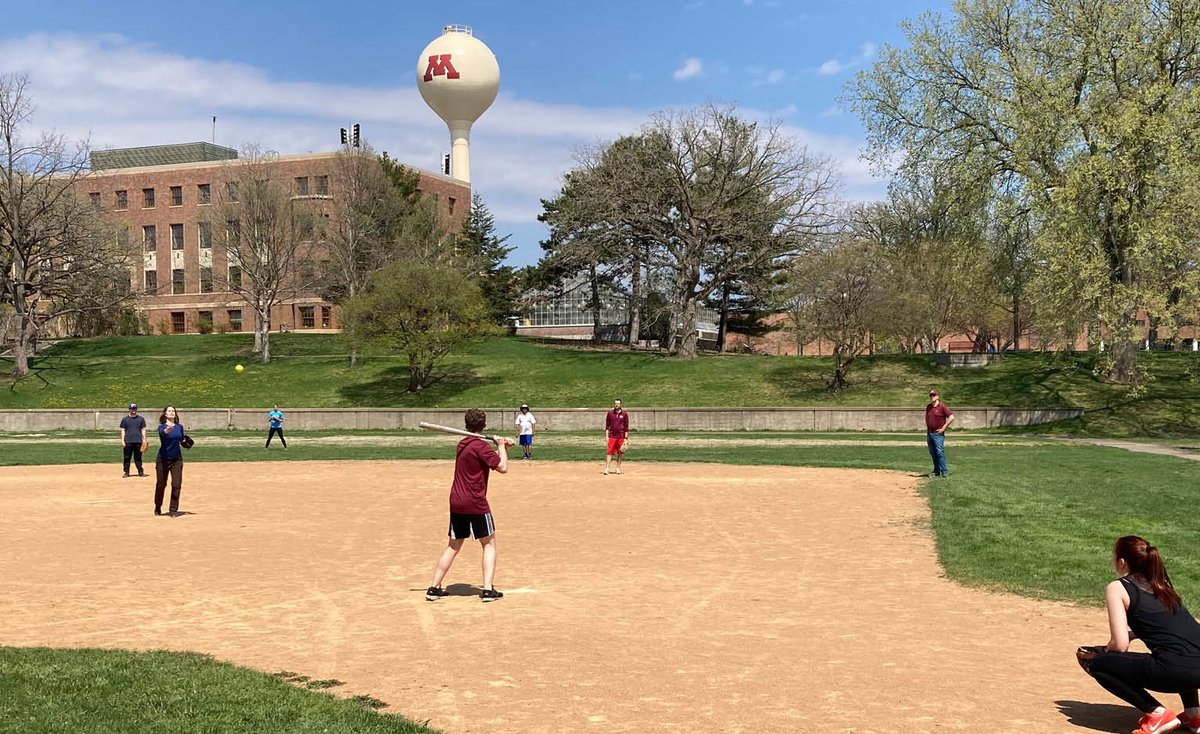 students and staff play softball with the CFANS watertower in the background