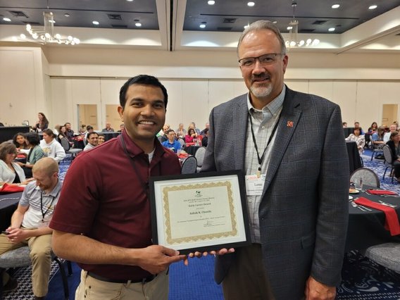 Ashok Chanda receives 2022 NC APS early career award plaque in a conference room