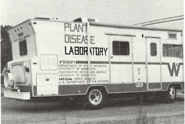 Black and white photo of Winnebago camp van with "Plant Disease Laboratory" on side