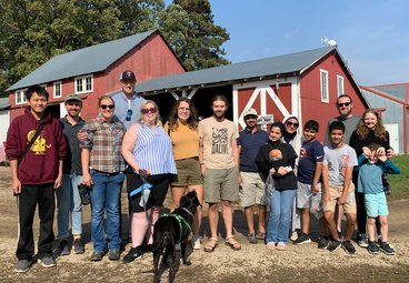 Hsuan Fu, Andrew, Alisha and her partner, Diane and her dog, Annie and her partner, Oadi and his family, and Matt and his family pose outside the Whistling Well barn
